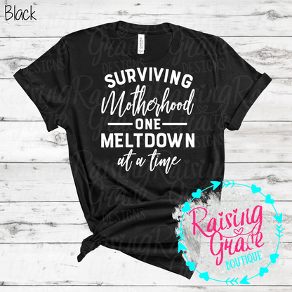 Surviving Motherhood One Meltdown At A Time Graphic T-Shirt | Funny Mom Tee | Boutique Mama Shirt | Relatable Mom Graphic Tee | Motherhood Shirt