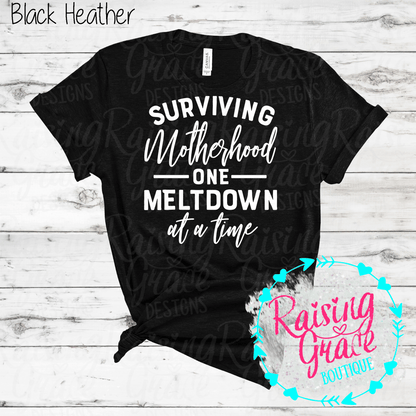 Surviving Motherhood One Meltdown At A Time Graphic T-Shirt | Funny Mom Tee | Boutique Mama Shirt | Relatable Mom Graphic Tee | Motherhood Shirt
