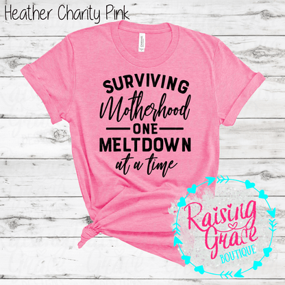 Surviving Motherhood One Meltdown At A Time Graphic T-Shirt | Funny Mom Tee | Boutique Mama Shirt | Relatable Mom Graphic Tee | Motherhood Shirt