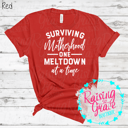 Surviving Motherhood One Meltdown At A Time Graphic T-Shirt | Funny Mom Tee | Boutique Mama Shirt | Relatable Mom Graphic Tee | Motherhood Shirt